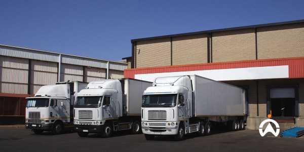Xe tải logistics chuỗi cung ứng lạnh màu trắng đậu trong kho để phân phối các sản phẩm nhạy cảm với nhiệt độ